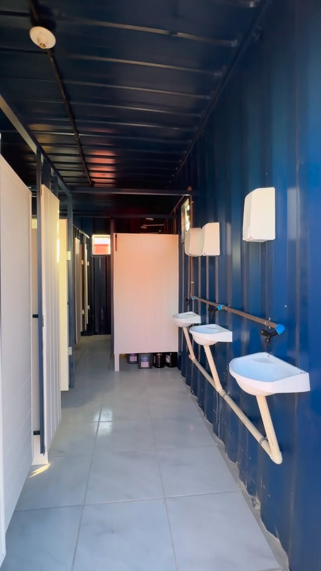 Interior de contêiner sanitário com cabines e lavatórios